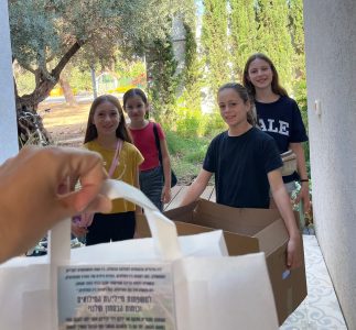 ילדי מועצת חוף כרמל מחלקים מארזים לבתים של מגויייסם בצו 8